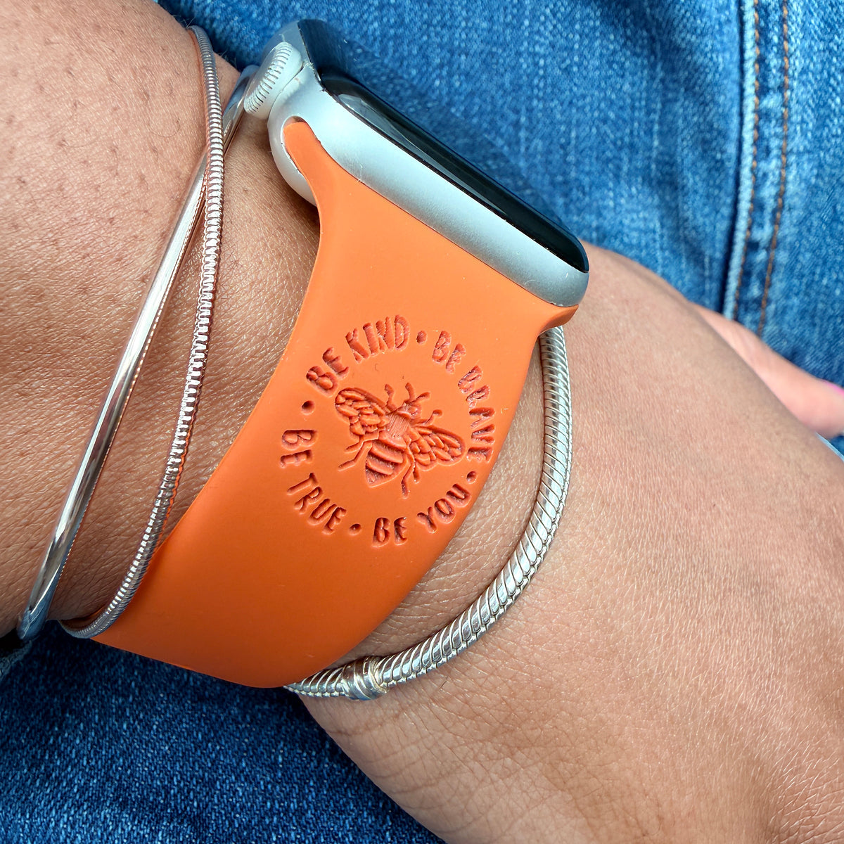Brave watch band for Apple Watch in rust with the Be Kind Be Brave Bee engraving, styled on a wrist