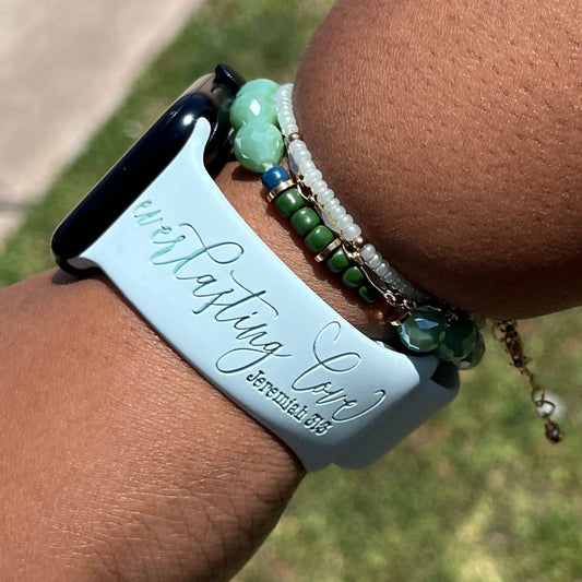 Ice blue Everlasting Love watch band for Apple Watch worn outdoors with green beaded bracelets