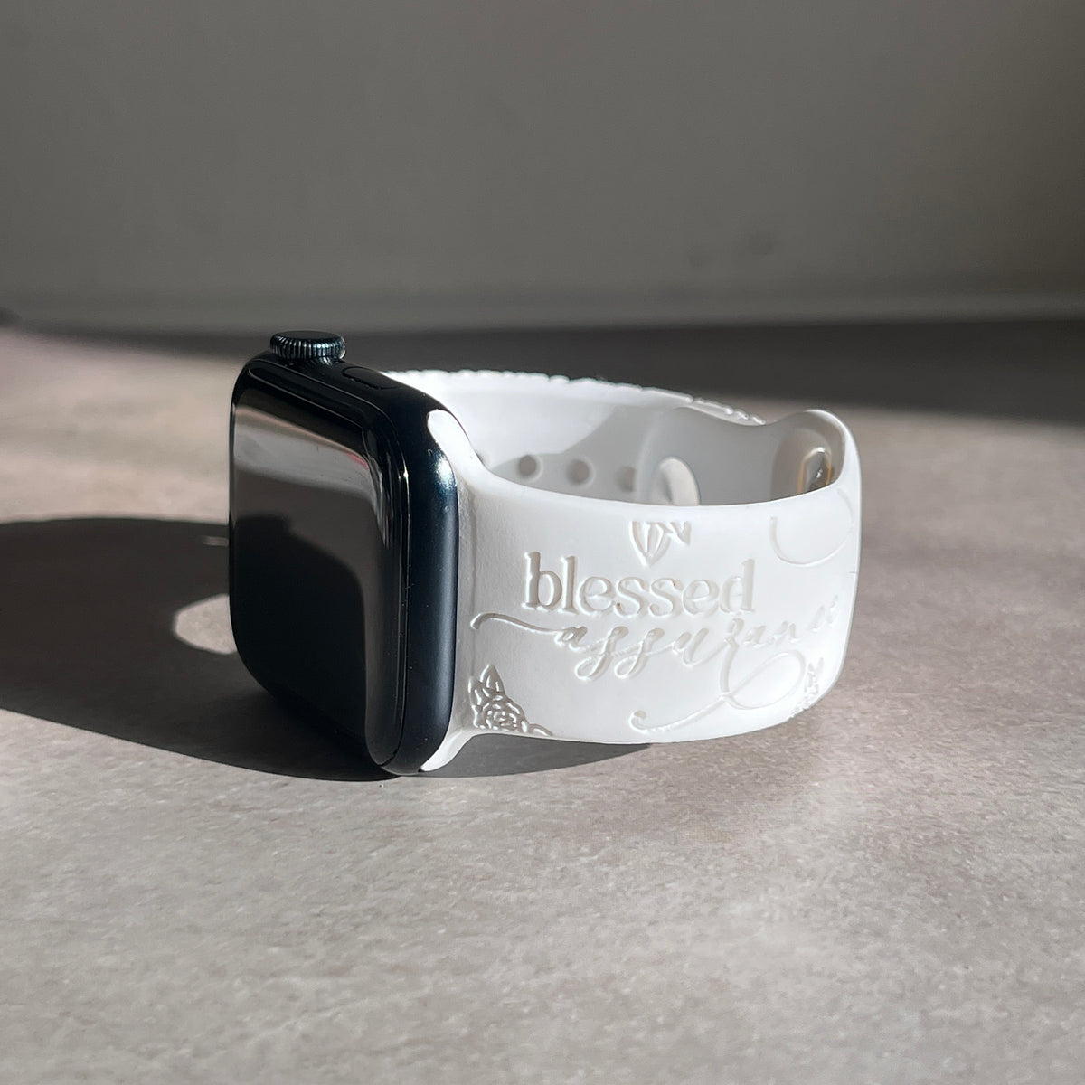 White Blessed Assurance engraved watch band for Apple Watch in natural sunlight
