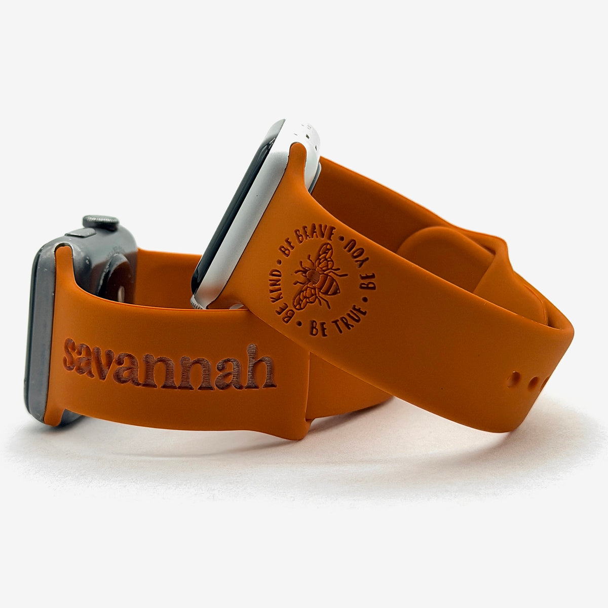 Rust Brave watch band for Apple Watch engraved with the Be Kind Be Brave Bee design, shown with a band engraved with the name Savannah