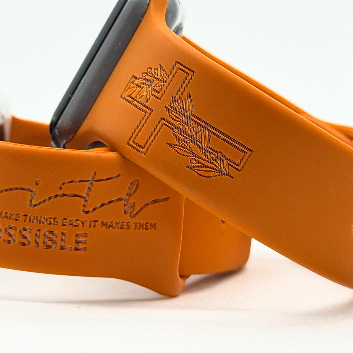 Close-up of the floral cross engraving on a rust Faith Makes It Possible watch band for Apple Watch