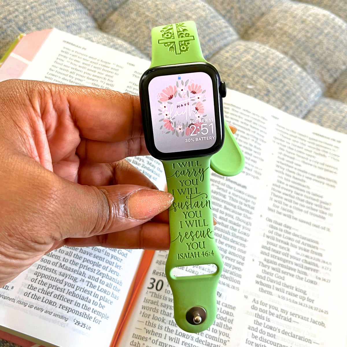 Green I Will Carry You watch band for Apple Watch held over an open Bible