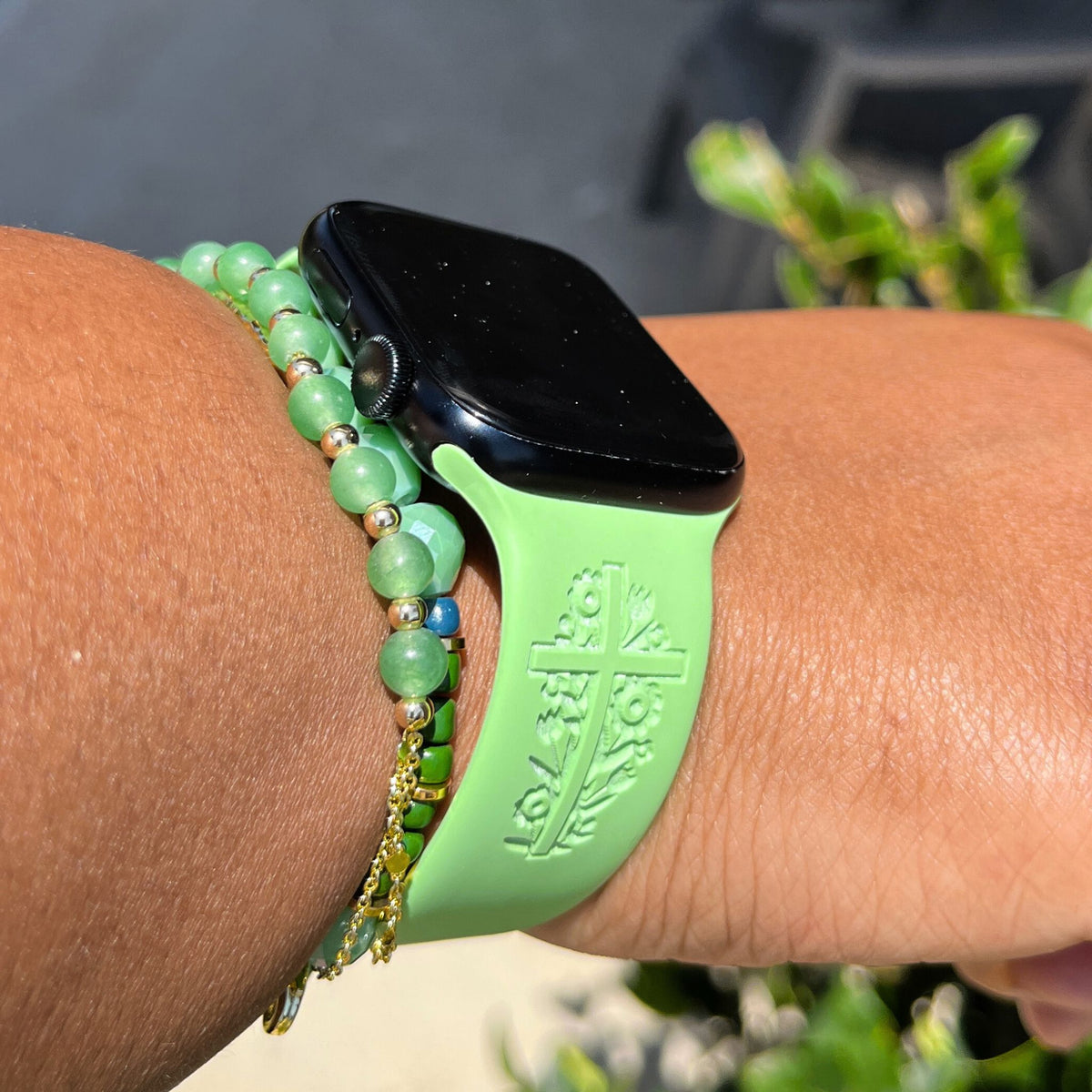 Side view of a green I Will Carry You watch band for Apple Watch worn with green bracelets