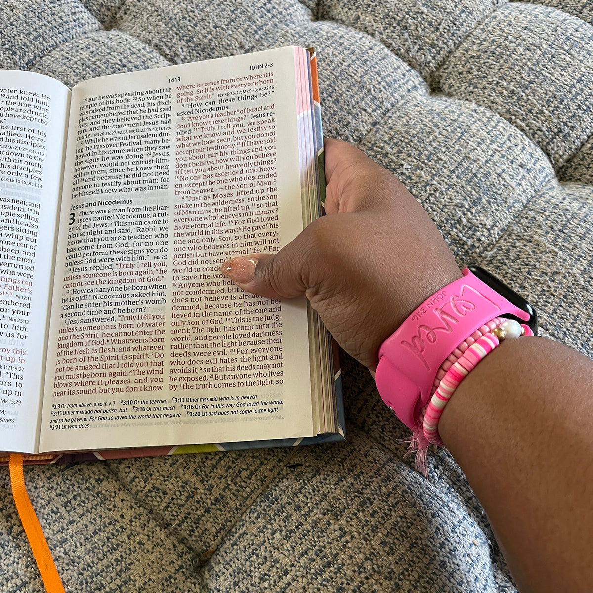 Loved John 3:16 watch band for Apple Watch worn while holding a Bible open to the Gospel of John