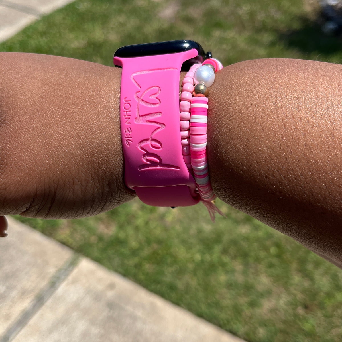Hot pink watch band for Apple Watch engraved with Loved and John 3:16, worn outdoors